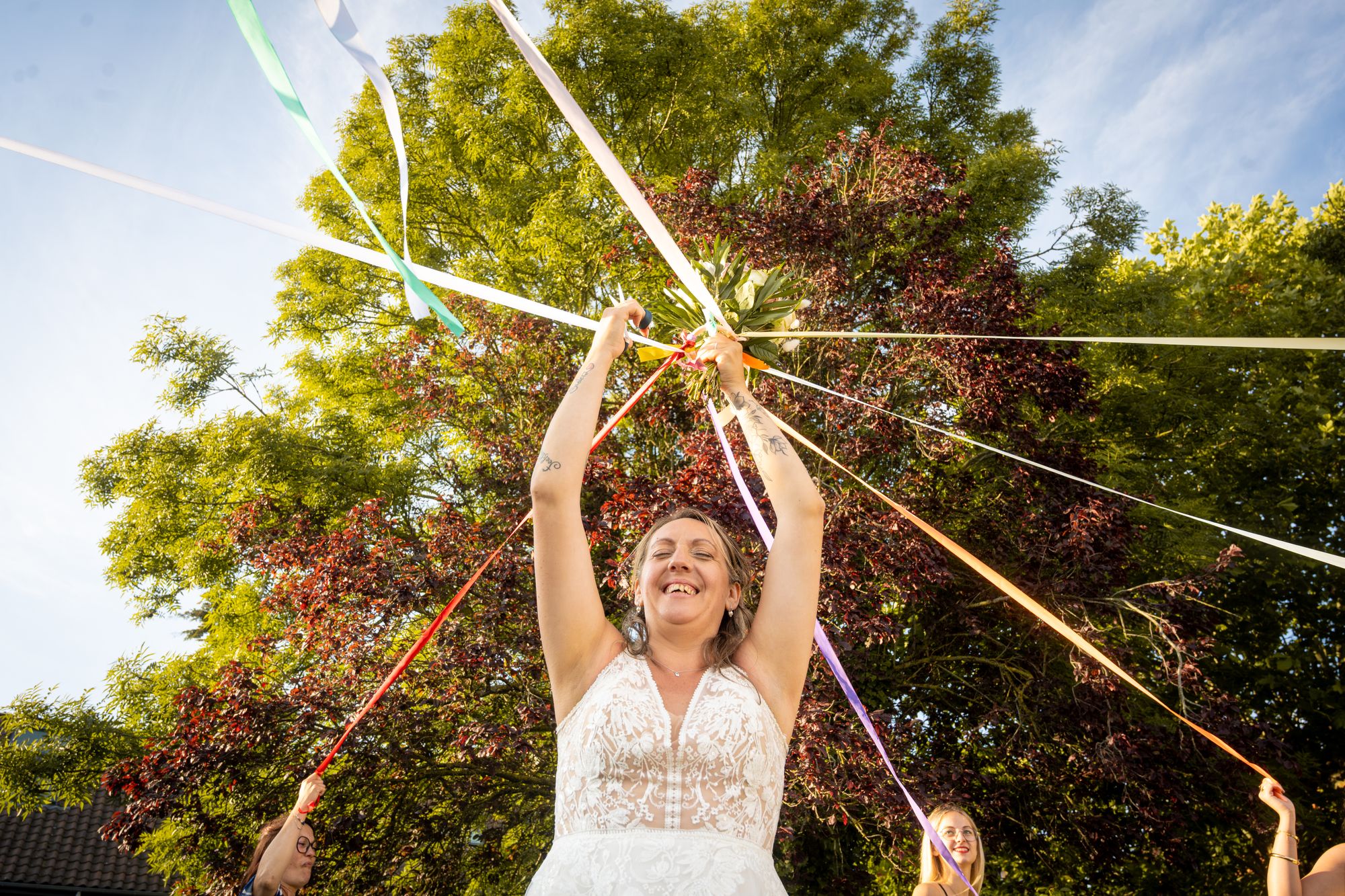 La mariée riant sous des rubans colorés